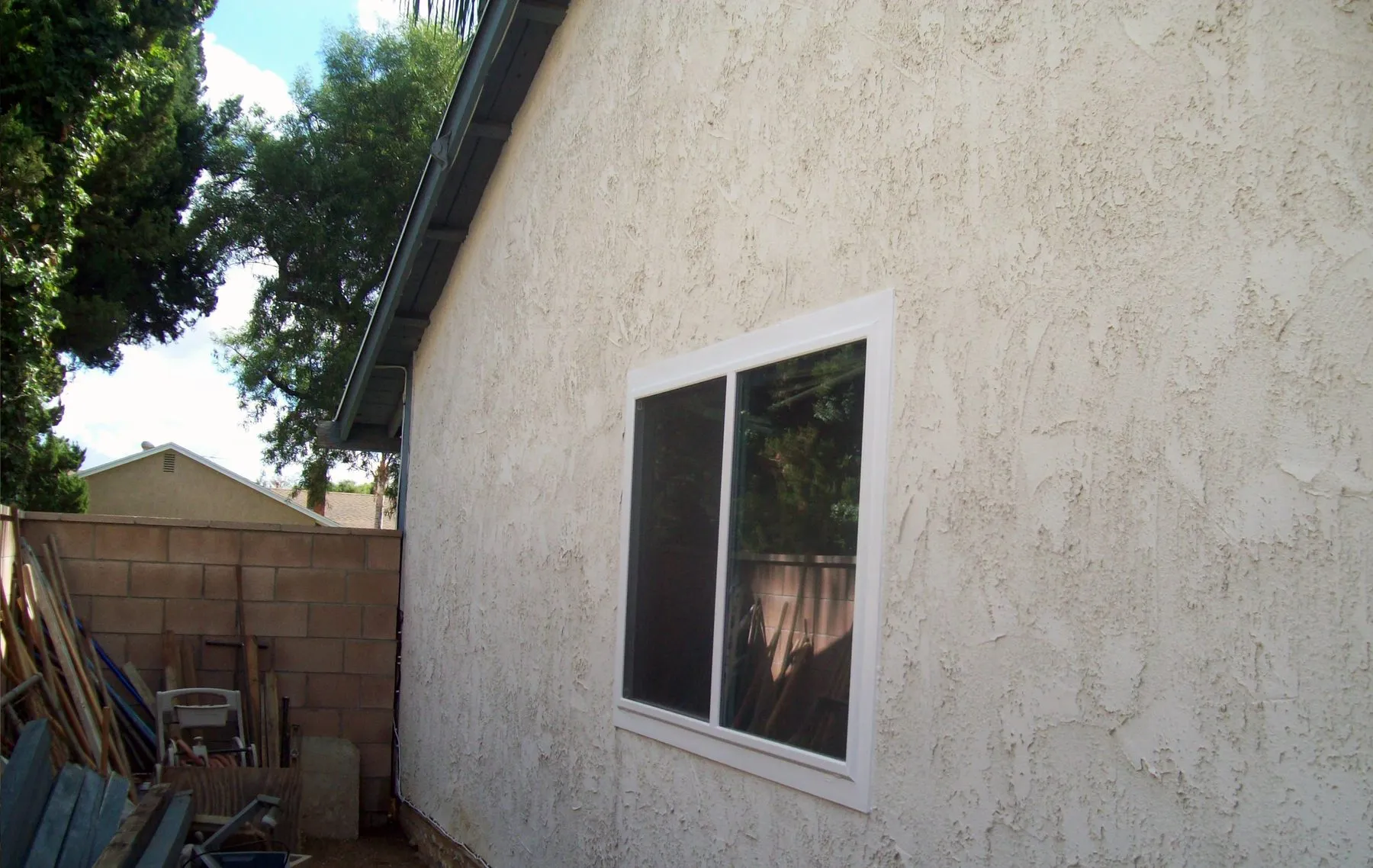 After: a side-yard corner window before and after replacement