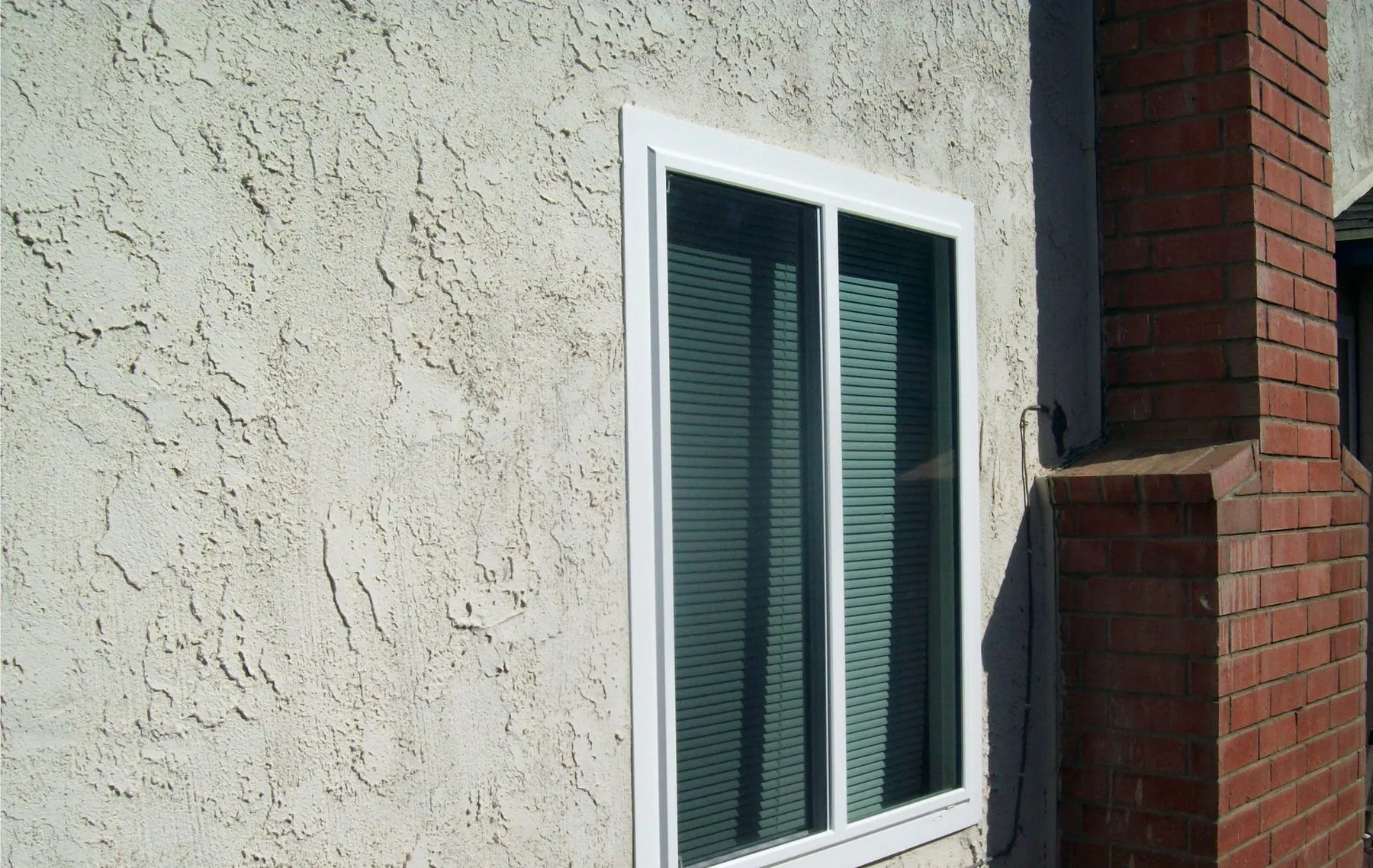 After: a corner window in a brick wall before and after replacement