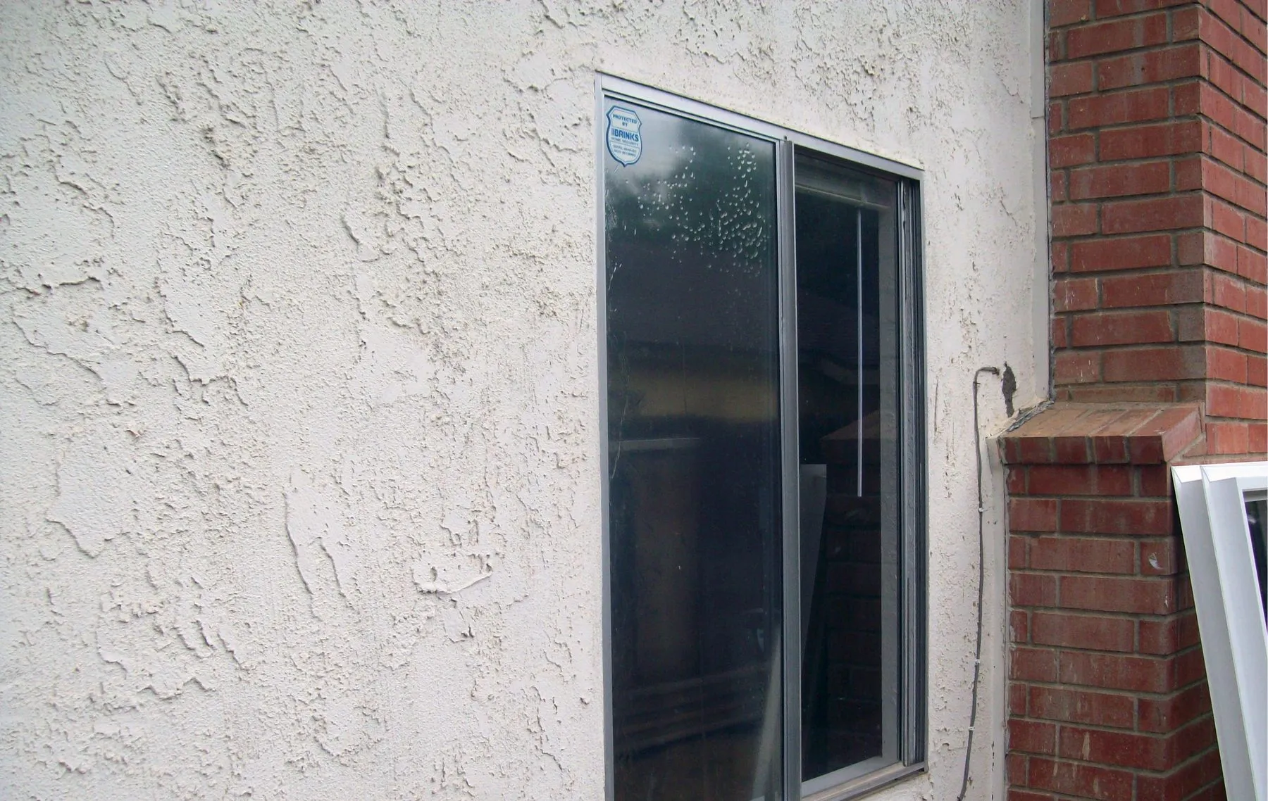 Before: a corner window in a brick wall before and after replacement