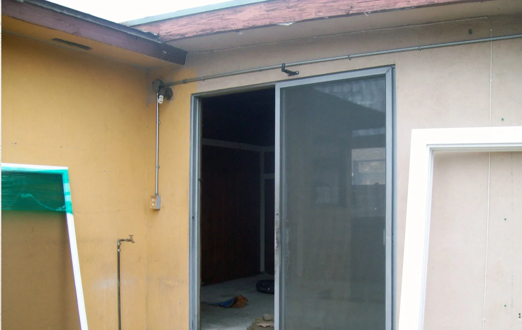 An old aluminum sliding glass door before replacement