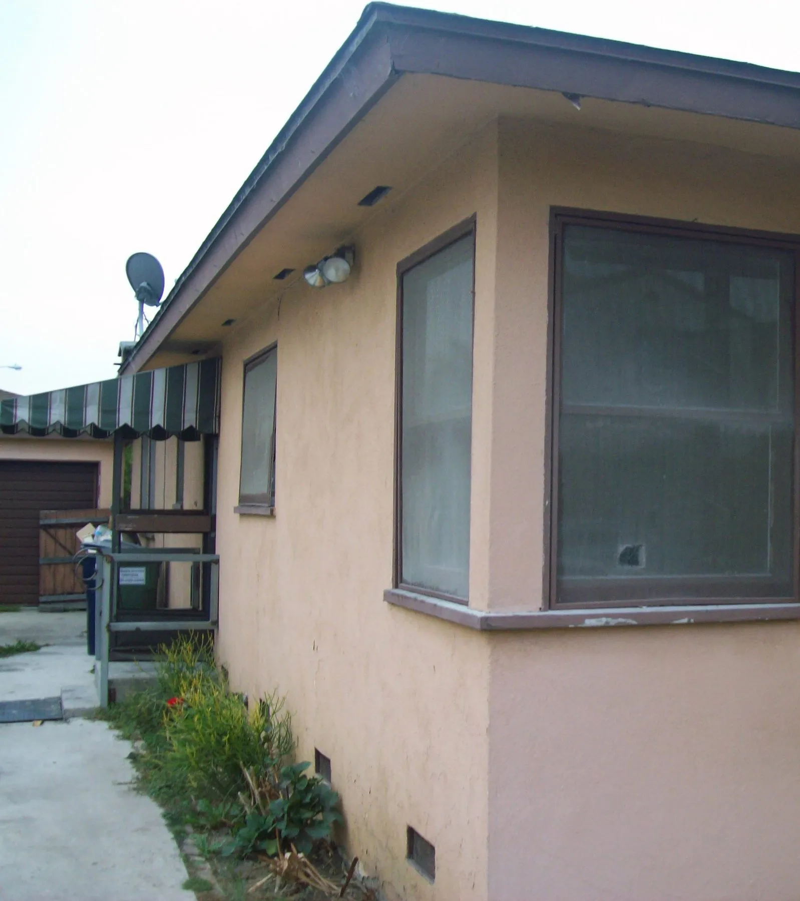 Before: two windows on the same corner of a house before and after replacement