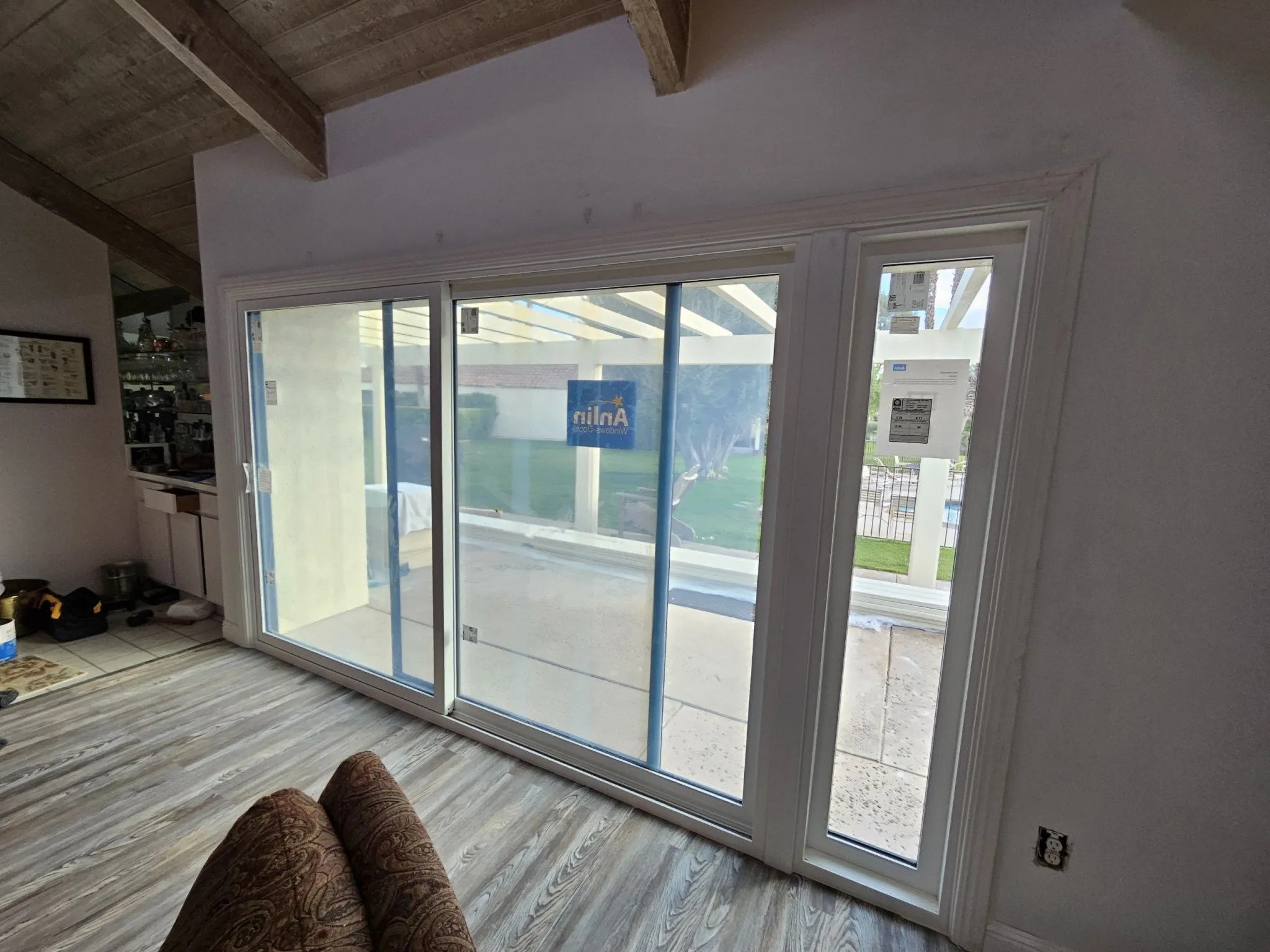 A sliding patio door mid-install with the spec sticker still on the glass